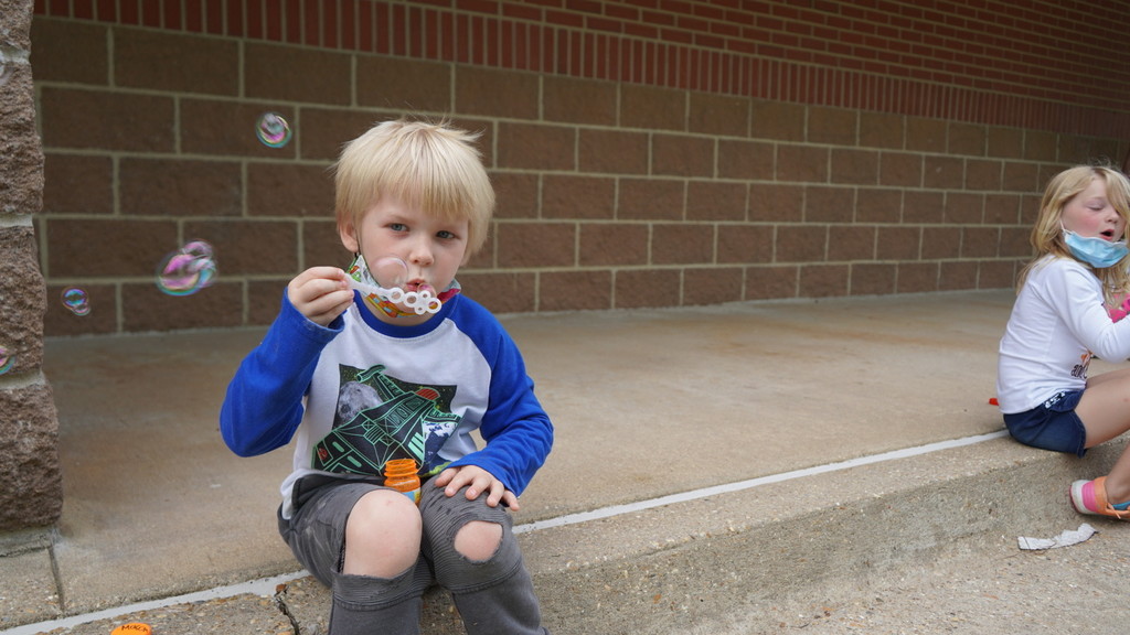 Image of an Sheridan Elementary School student blowing bubbles