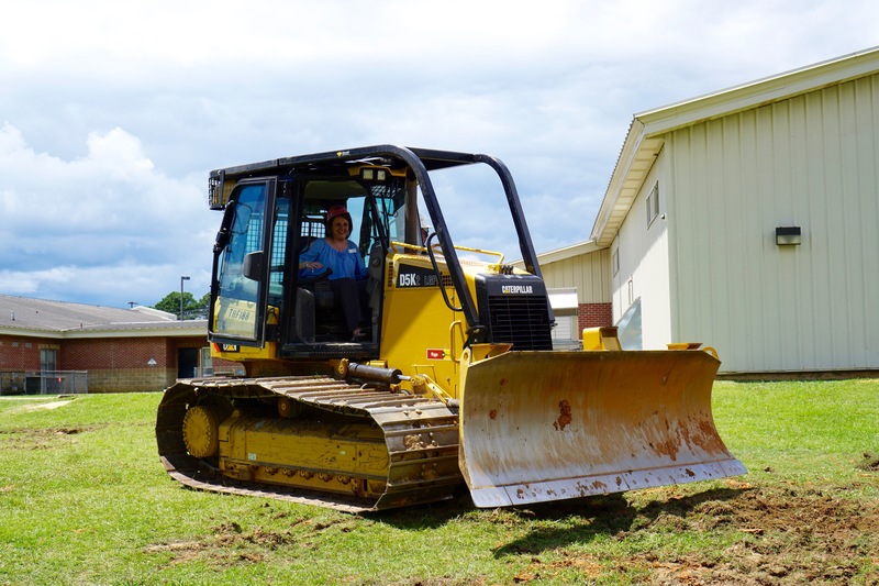 Assistant Principal Teresa Knight operates back hoe at SIS groundbreaking ceremony